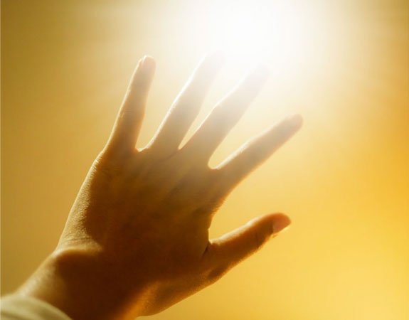 Hand outstretched to block the bright sun