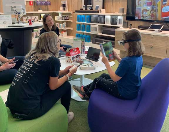 Women wearing eSight's low vision technology gives a presentation at work as part a corporate social responsibility partnership with Microsoft Partner