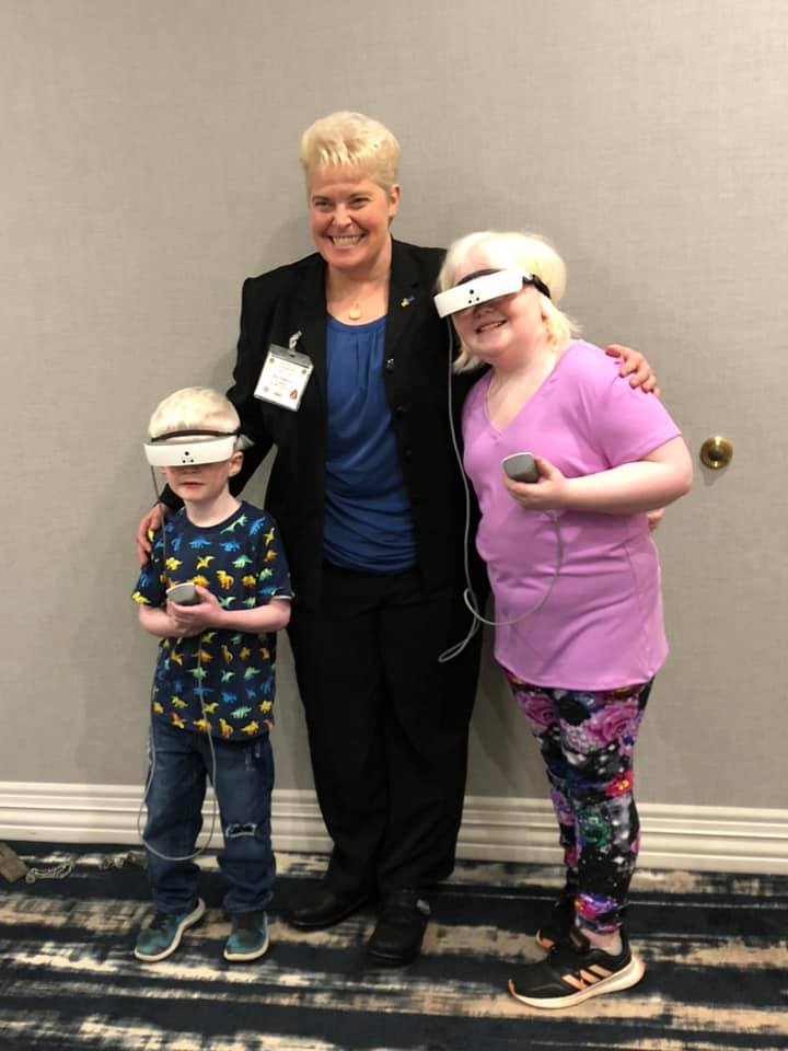 Dr. Mary pictured with the Collins siblings, both of who live with Ocular Albinis,
