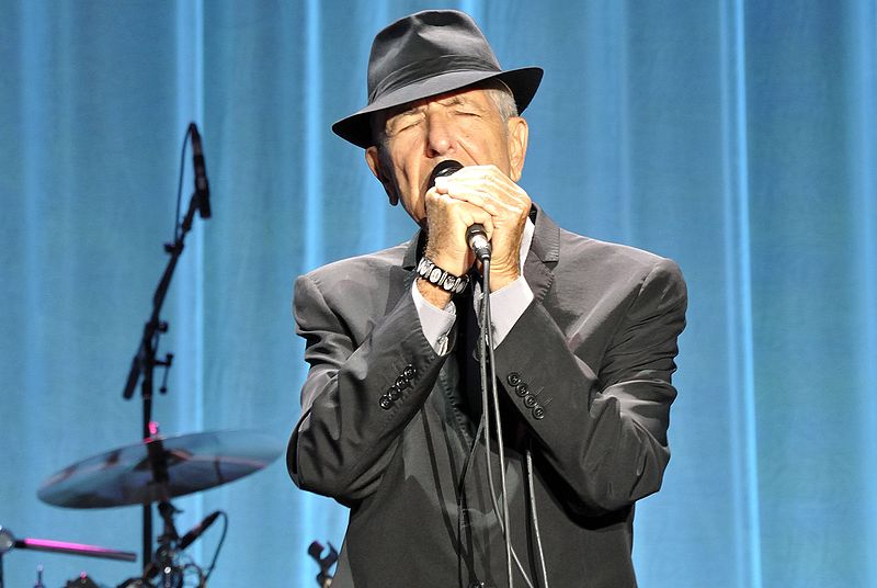 Leonard Cohen performing on-stage.