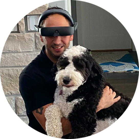 Chris is wearing eSight 4 and photographed with his dog