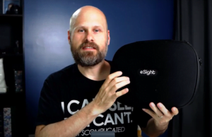 Sam from The Blind Life holding a case that contains an eSight 4 device