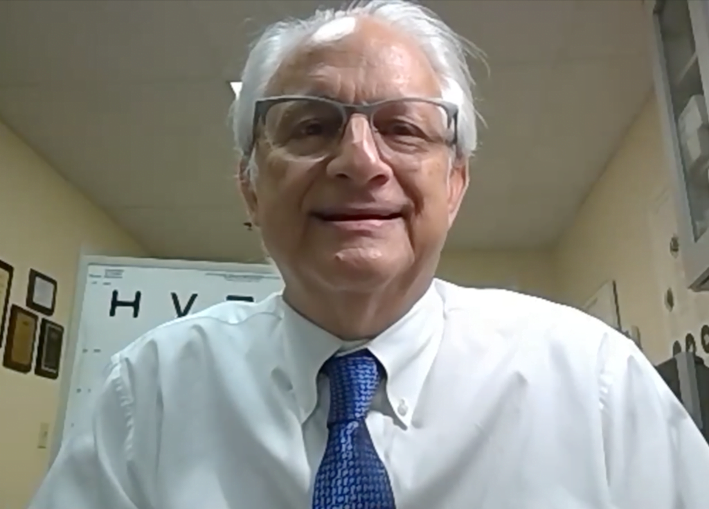 Dr. Scott Gartner, a low vision specialist,  looks at camera wearing a white collared shirt and blue tie as he talks about the new eSight 4