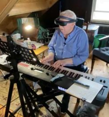 Claude using his eSight 4 to read music and play the piano.